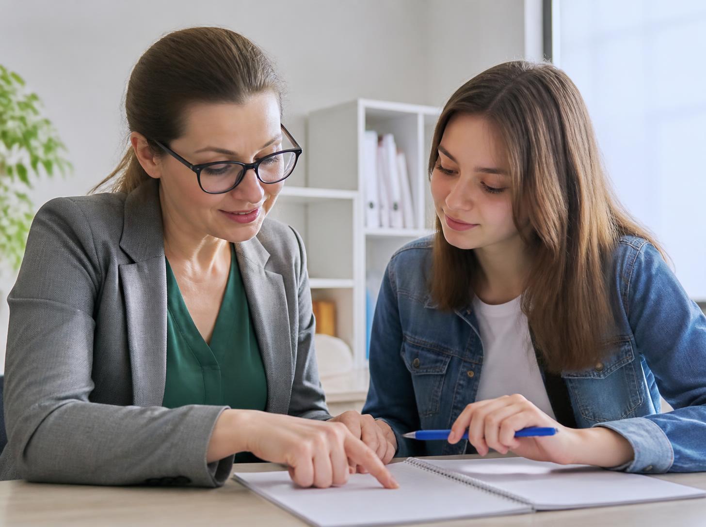 A teacher and student at a desk
